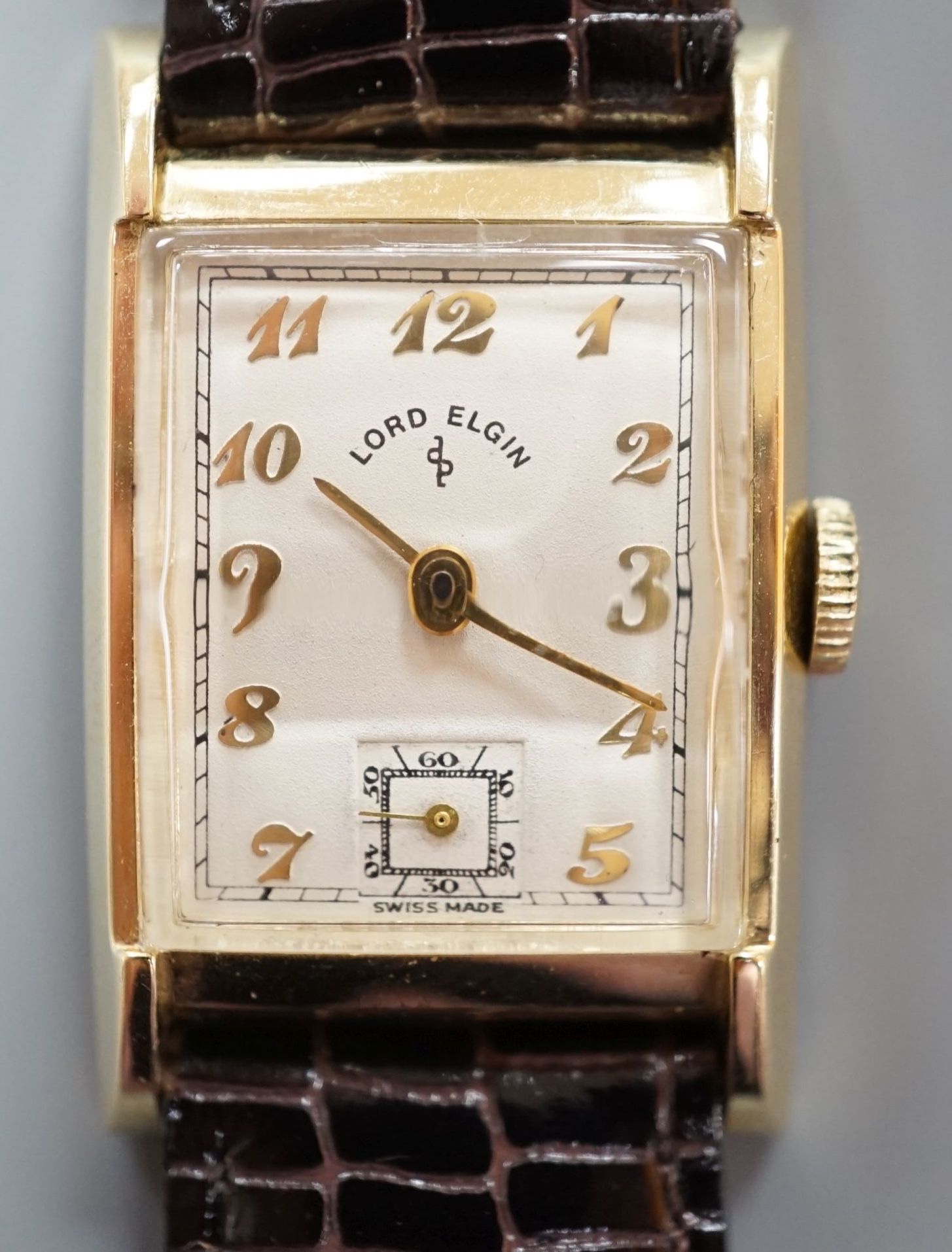 A gentleman's 1950's 14ct Lord Elgin manual wind wrist watch, with angular glass, Arabic dial and subsidiary seconds, on later leather strap, case diameter 23mm, gross weight 24.7 grams.